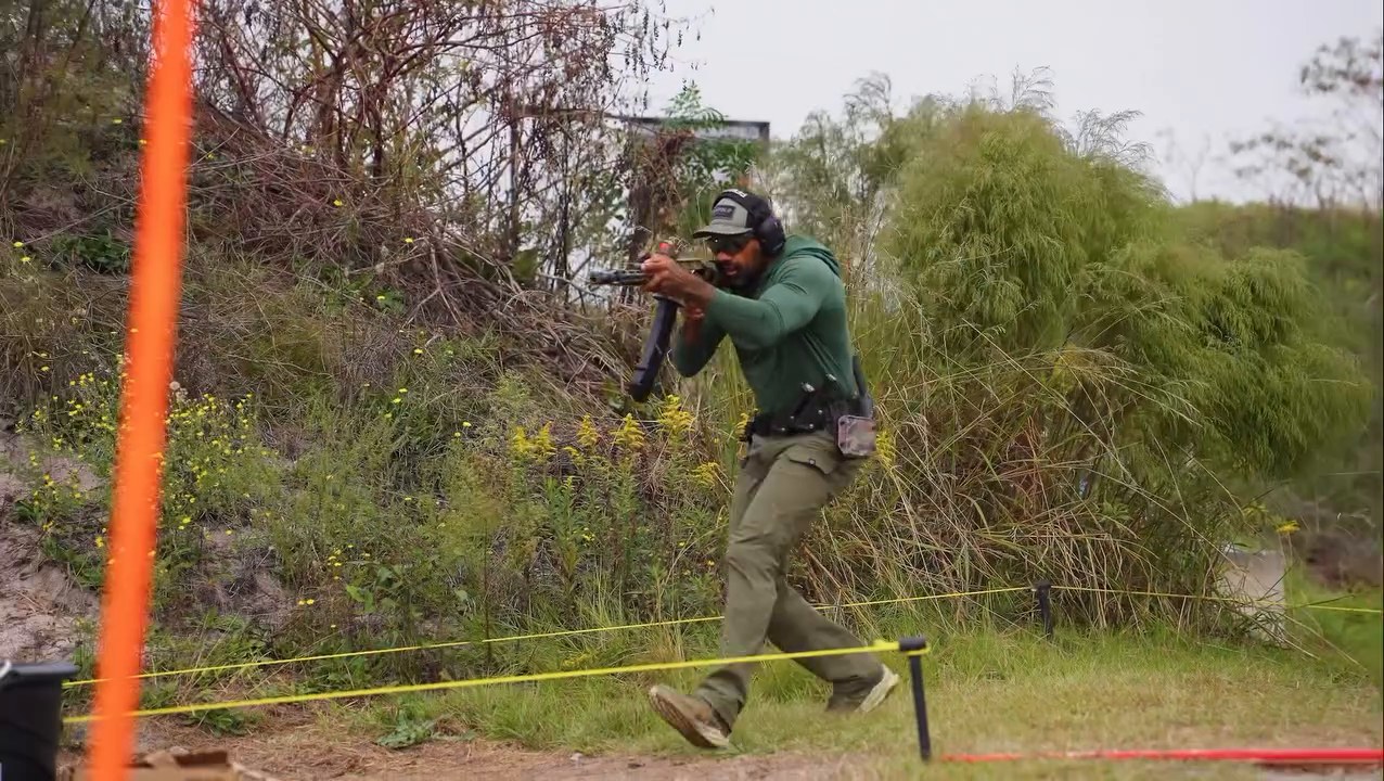 A competitor moves between positions on a wooded stage